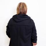 woman wearing a black French Terry jacket against a white background. 
