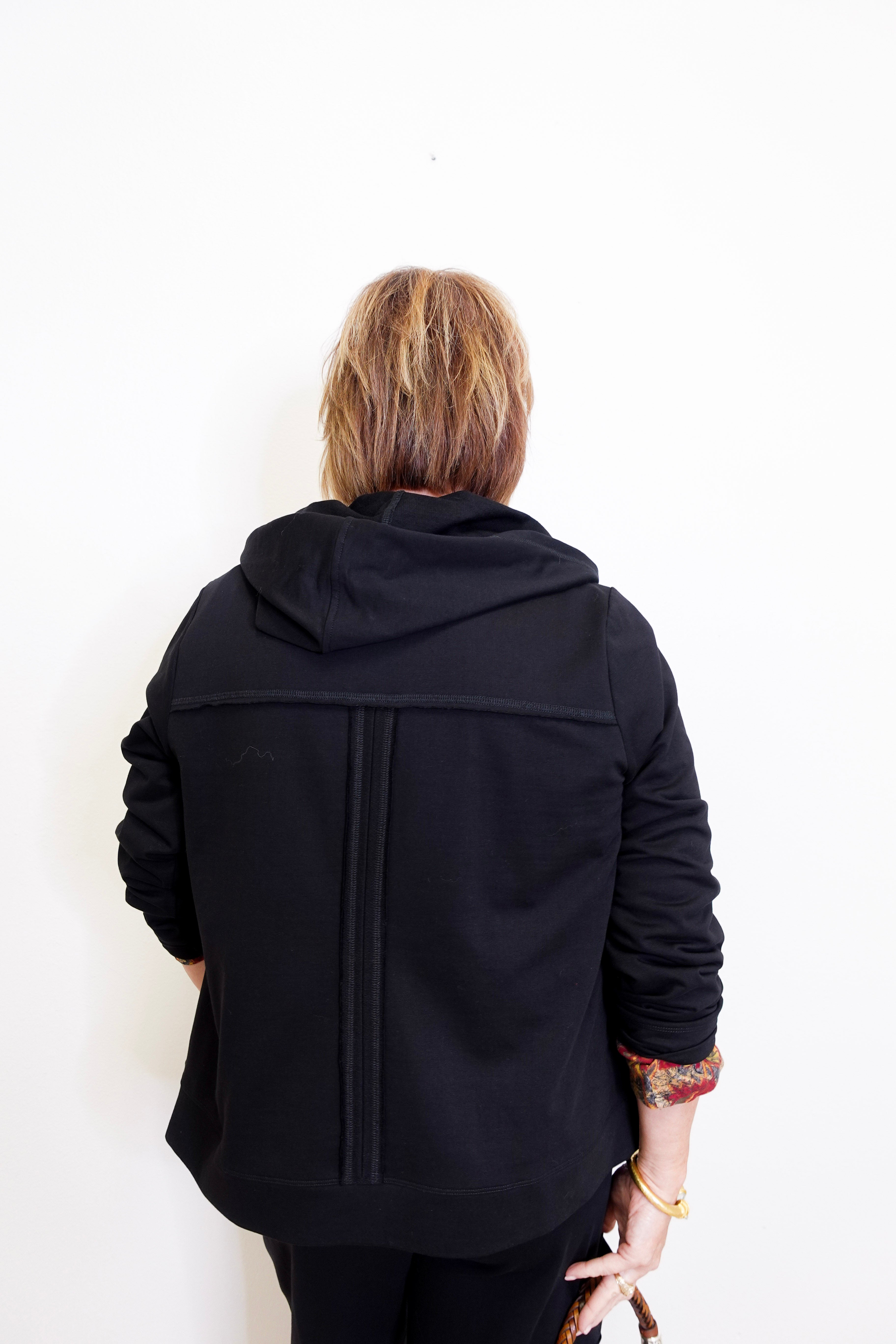woman wearing a black French Terry jacket against a white background. 