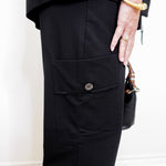 woman wearing a black pant against a white background. 