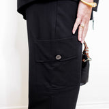 woman wearing a black pant against a white background. 