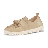 A gold loafer shoe with a tassel on top against a white background. 