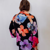 Person wearing a colorful floral kimono against a white background