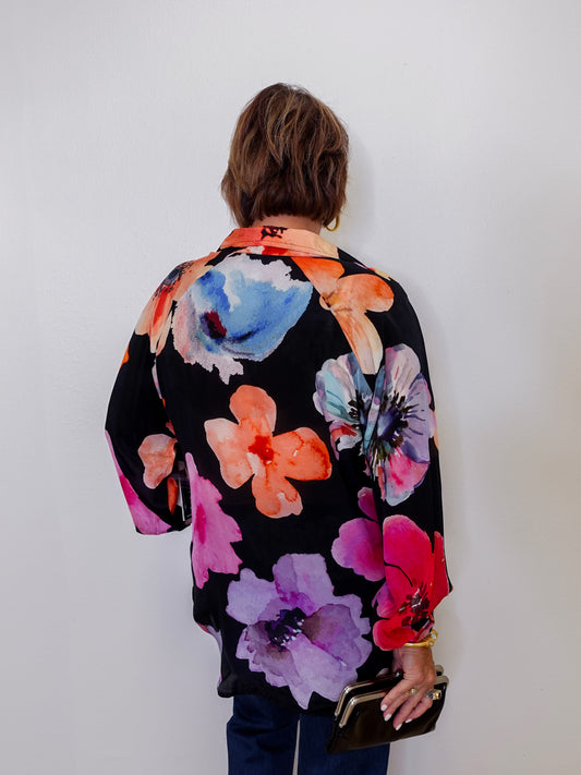 Person wearing a colorful floral kimono against a white background