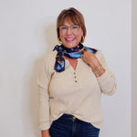 woman wearing a tan waffle knit blouse against a white background.
