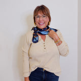 woman wearing a tan waffle knit blouse against a white background.