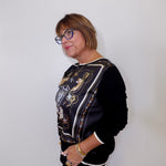 Person wearing a black jacket with a patterned design against a white background