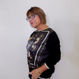Person wearing a black jacket with a patterned design against a white background