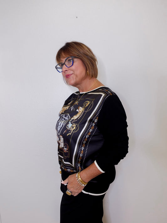 Person wearing a black jacket with a patterned design against a white background