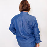 Person wearing a blue Karen Kane denim shirt against a white background
