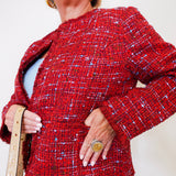 Person wearing a red textured jacket with a plain background