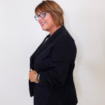 Woman wearing a black blazer against a white background