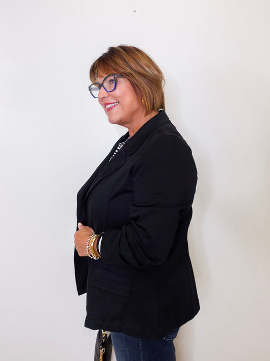 Woman wearing a black blazer against a white background