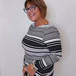 Woman wearing a black and white striped shirt against a plain background