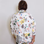 Person wearing a colorful patterned shirt with a plain background