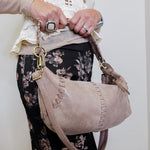 women wearing a hobo opal mini shoulder bag against a white background. 