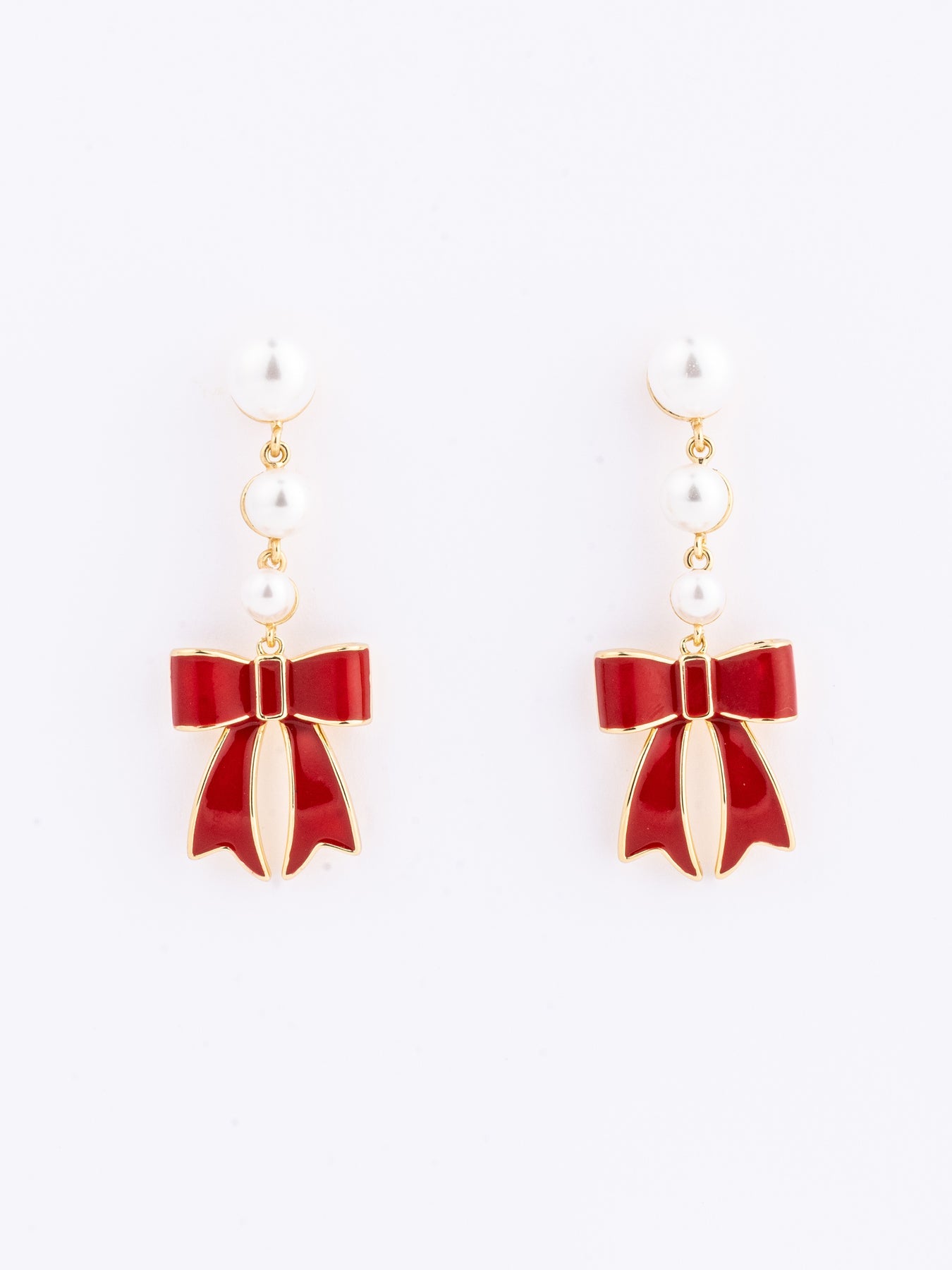 pearl drop earrings with a red bow against a white background. 
