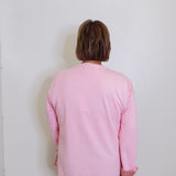 woman wearing a pink sweatshirt against a white background. 