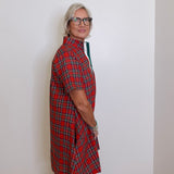 woman wearing a plaid short sleeve dress against a white background