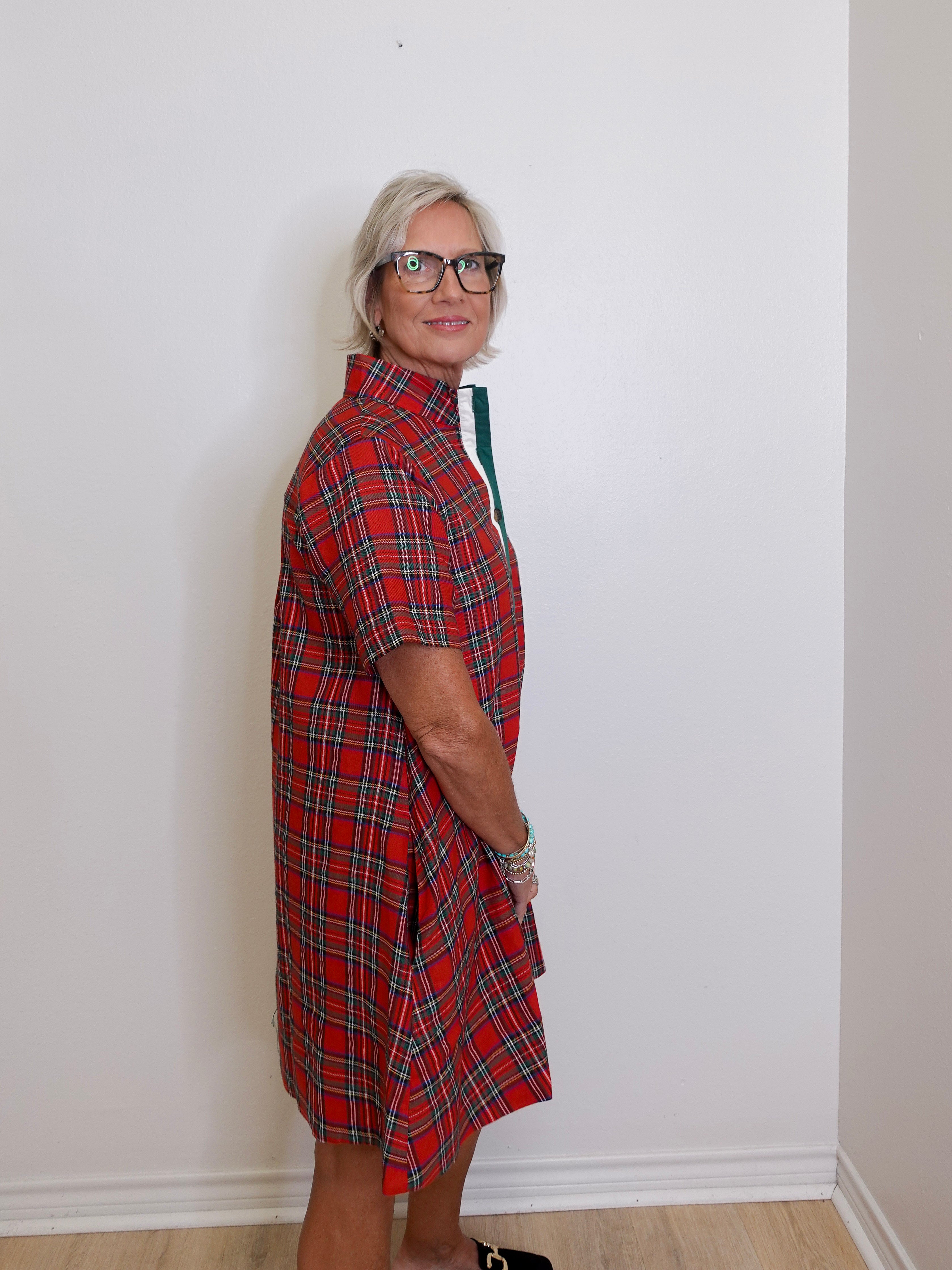 woman wearing a plaid short sleeve dress against a white background