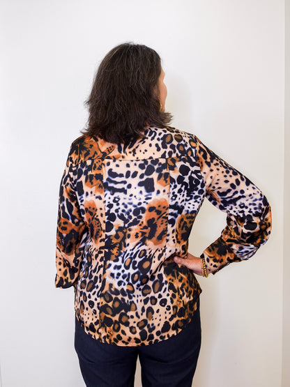 Person wearing a leopard print top against a white background