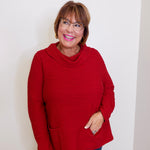 Woman wearing a red sweater against a white background