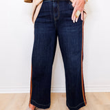 Person wearing dark blue jeans with a white background