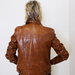 Person wearing a brown leather jacket against a white background