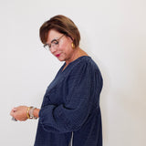 Woman wearing a navy blue textured sweater against a white background