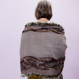 Person wearing a patterned shawl with a white background