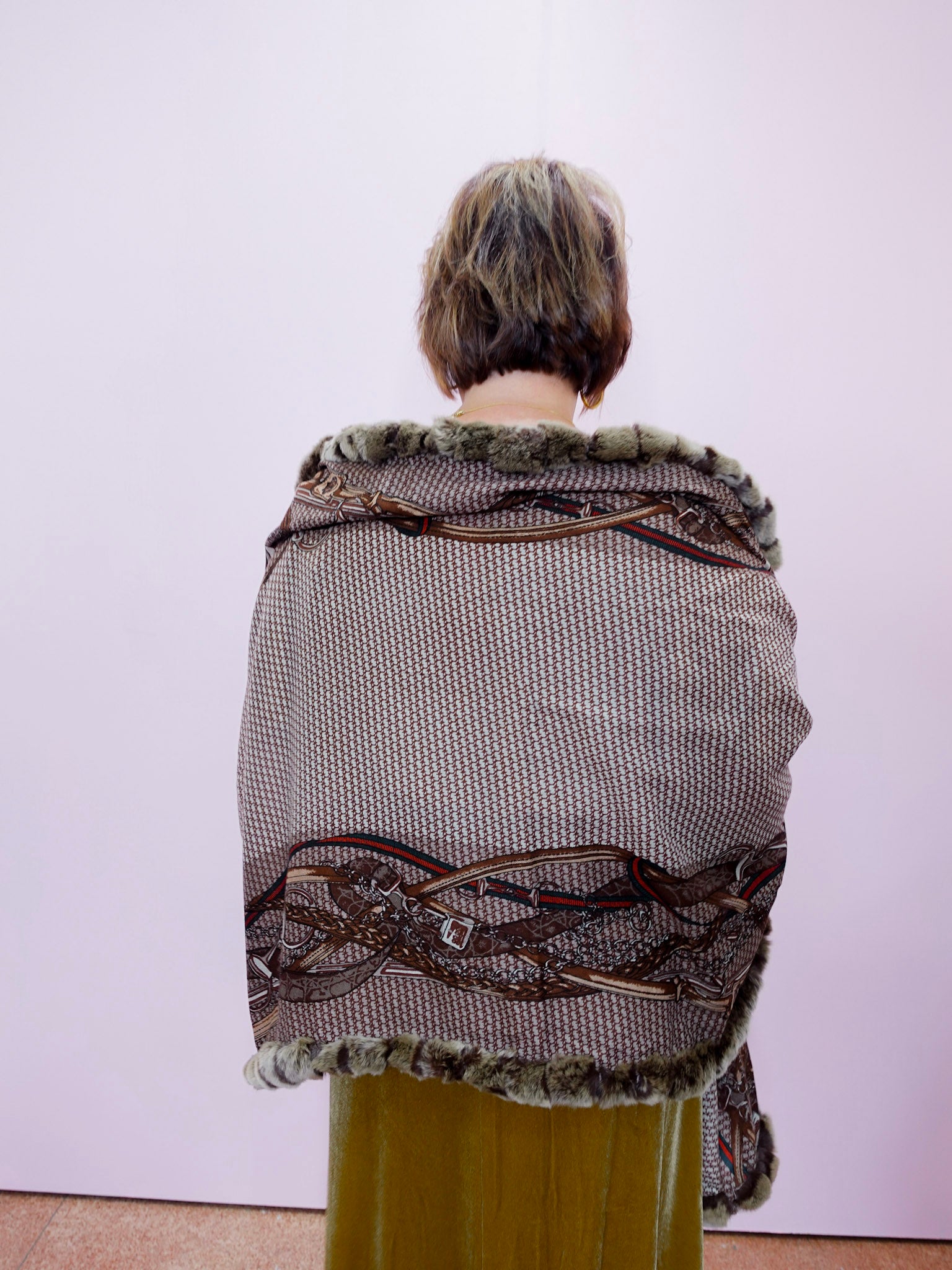 Person wearing a patterned shawl with a white background