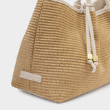 Woven straw bag with rope handles on a light gray background
