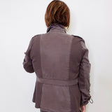 Person wearing a brown jacket and pants against a white background