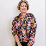 Woman wearing a floral print zip front hooded jacket. 