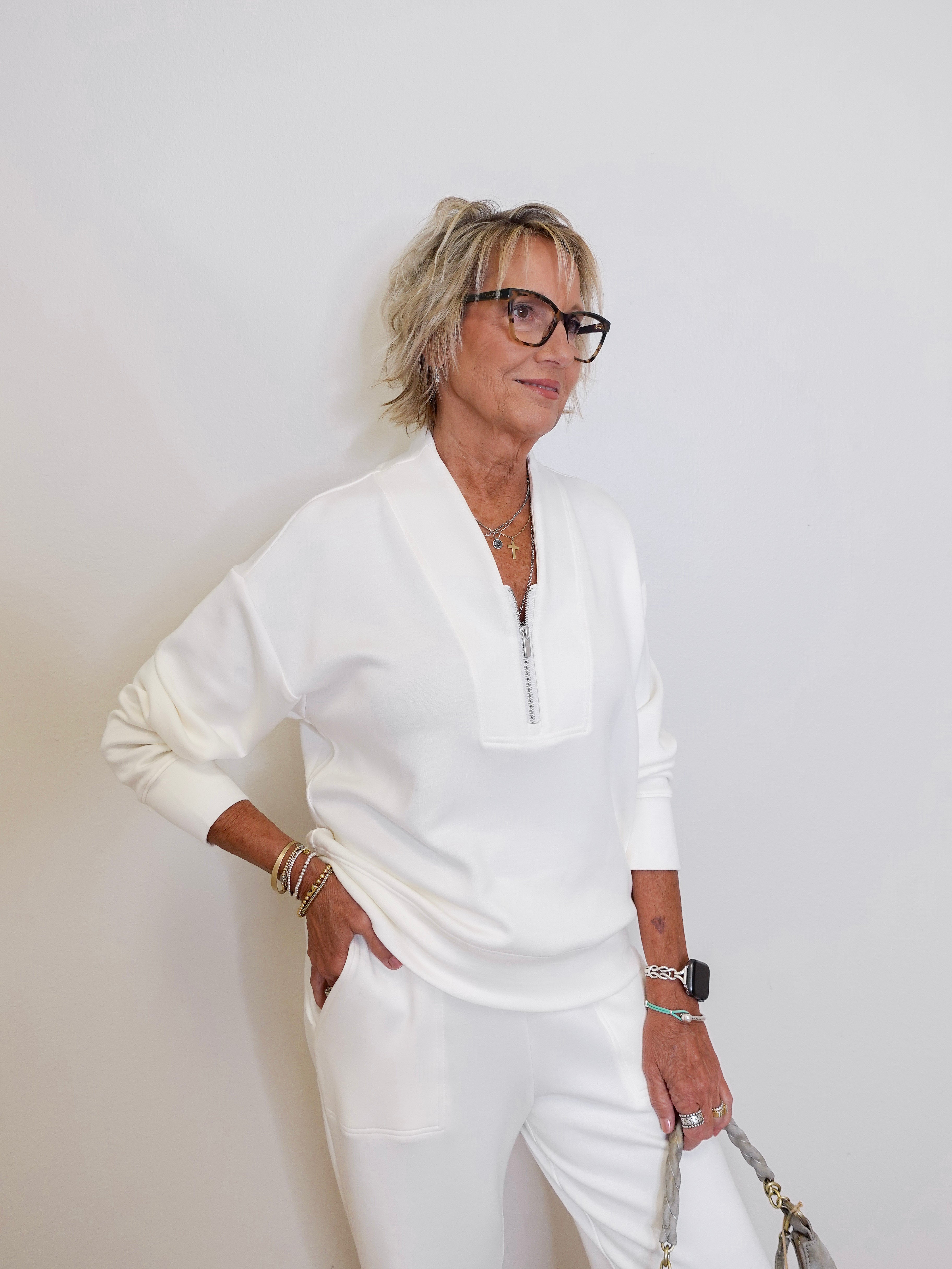 Woman wearing a white outfit against a plain background