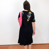 Woman modeling a Zivana ruffle knit midi dress featuring a black knit fabric, vibrant floral embroidery, short sleeves, and a ruffled hem.