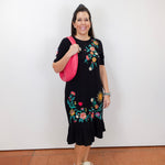 Model wearing the Zivana ruffle knit midi dress in black with colorful floral embroidery and ruffled hem.