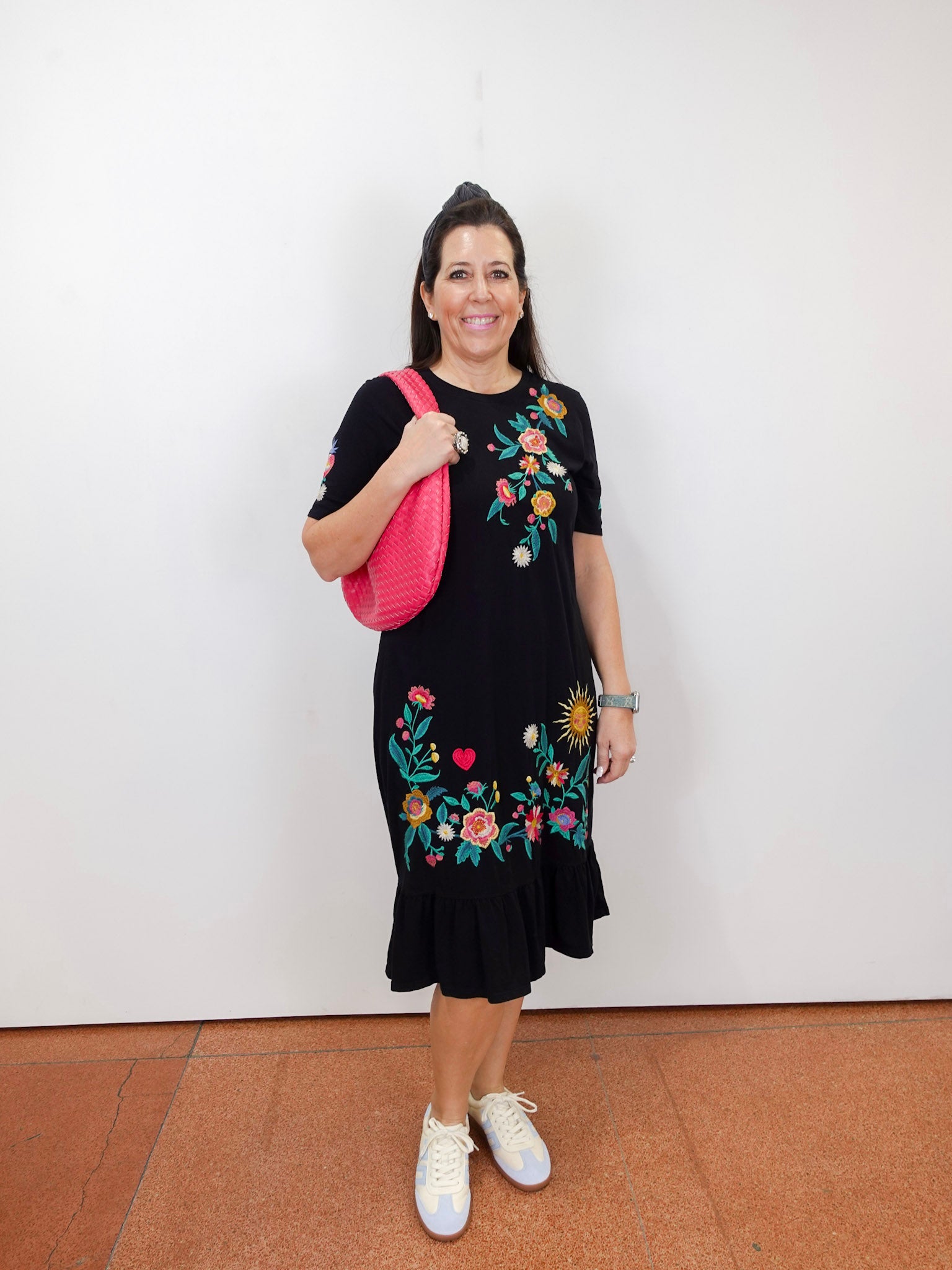 Model wearing the Zivana ruffle knit midi dress in black with colorful floral embroidery and ruffled hem.